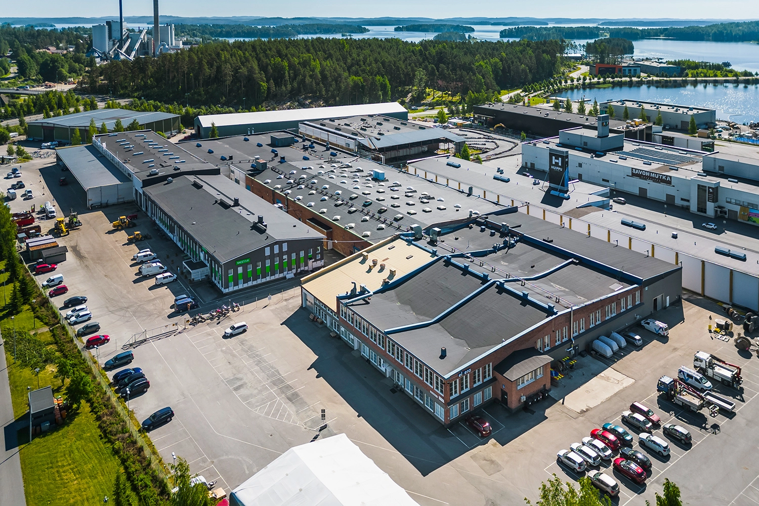 Ilmakuva Kuopion Varikkokatu 2 -kiinteistöstä. Etummaisena punatiilinen rakennusosa, jonka edessä pysäköintialue.