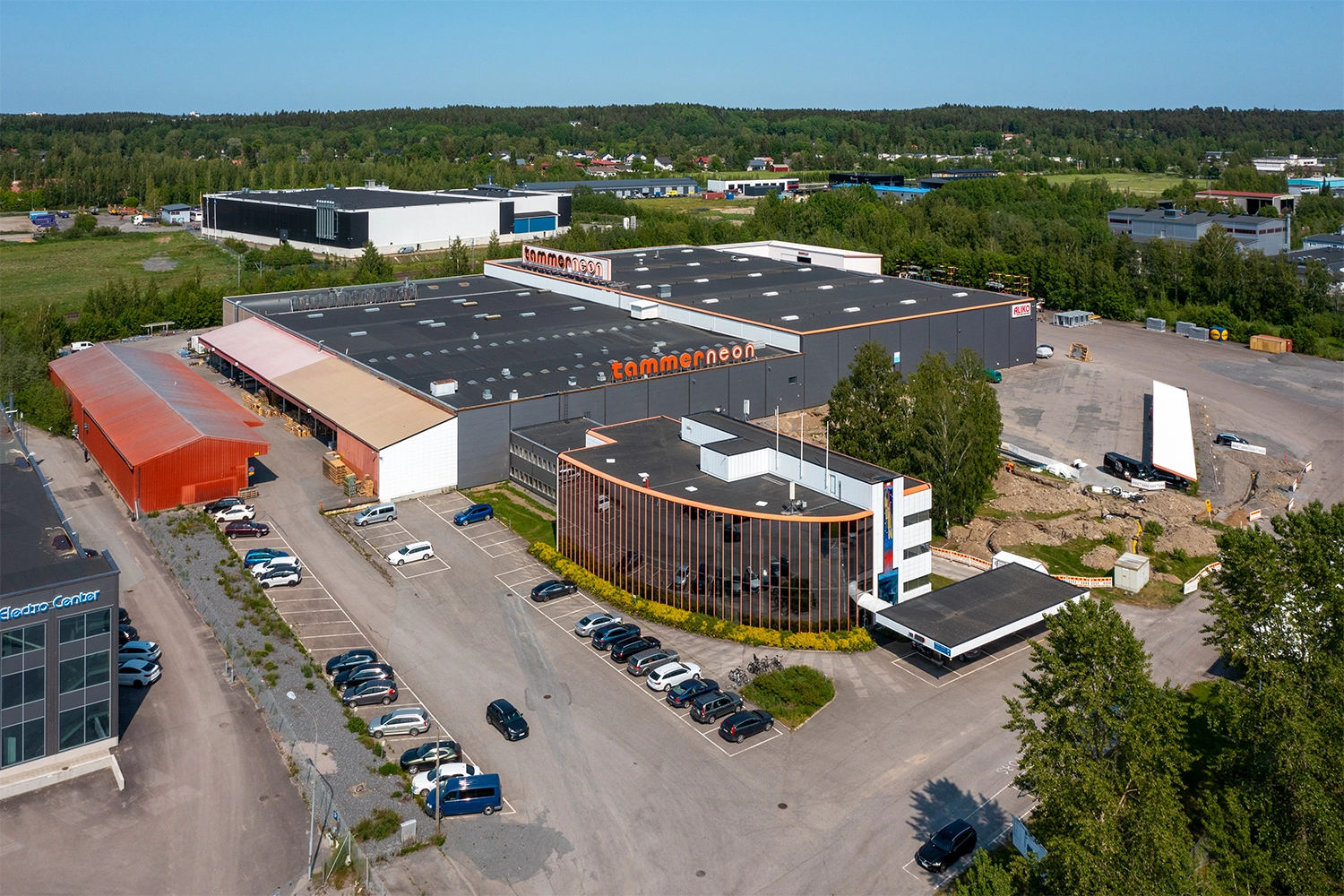 Tampereen Yrittäjänkulma 5 ilmakuvassa. Kiinteistössä on suuri teollisuushalli, lasijulkisivuinen toimistosiipi ja pihassa ulkovarastoa.